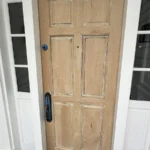 Wood entry door with side windows installed and prepared for finish in Los Angeles