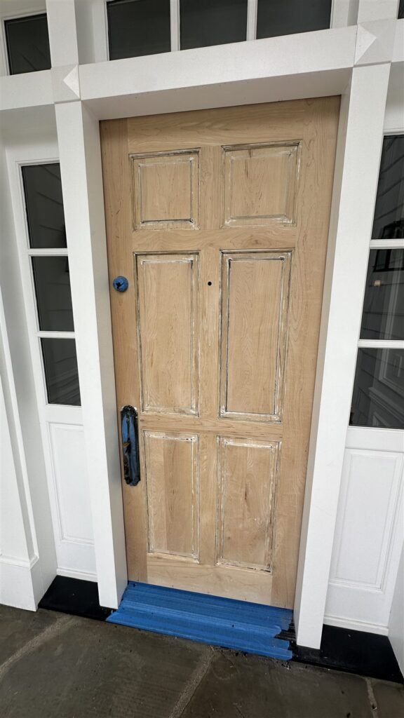Wood entry door with side windows installed and prepared for finish in Los Angeles