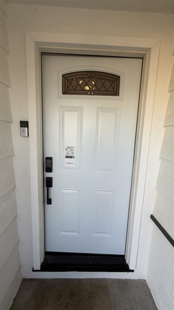 New white entry door with decorative glass and smart lock installed in Los Angeles
