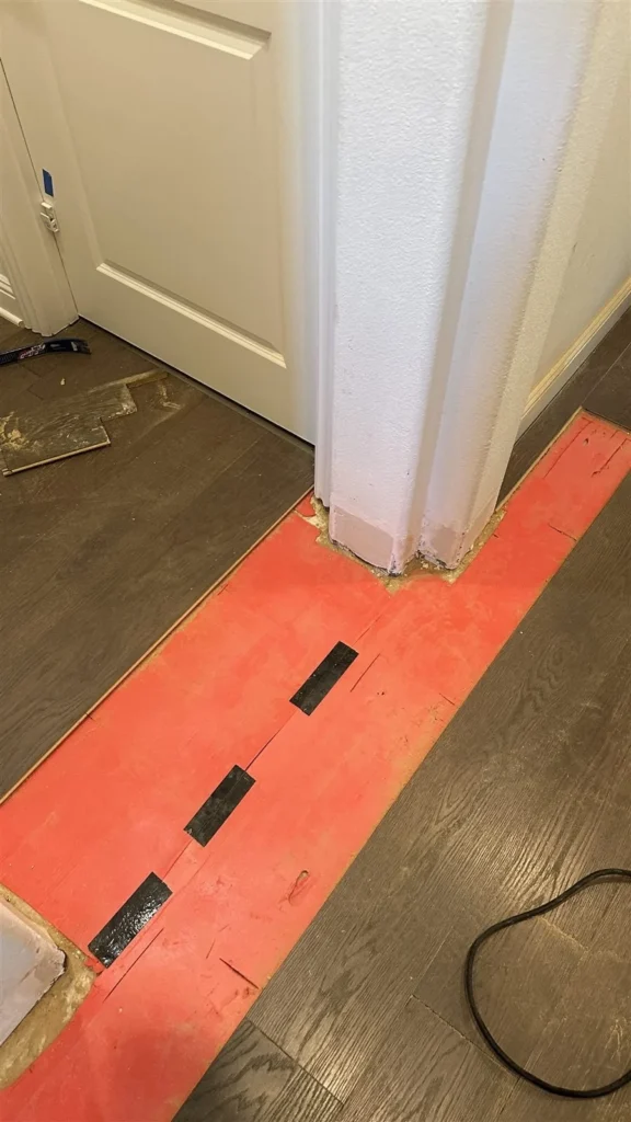 Floor transition strip being installed at a Los Angeles doorway