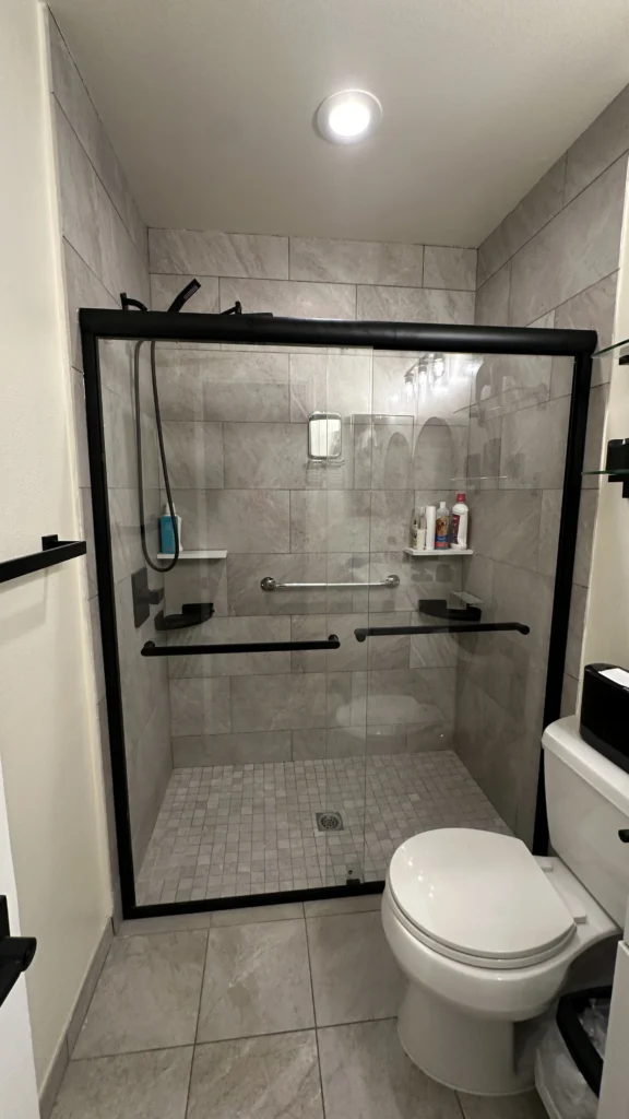 Glass shower door installed next to the toilet in a bathroom