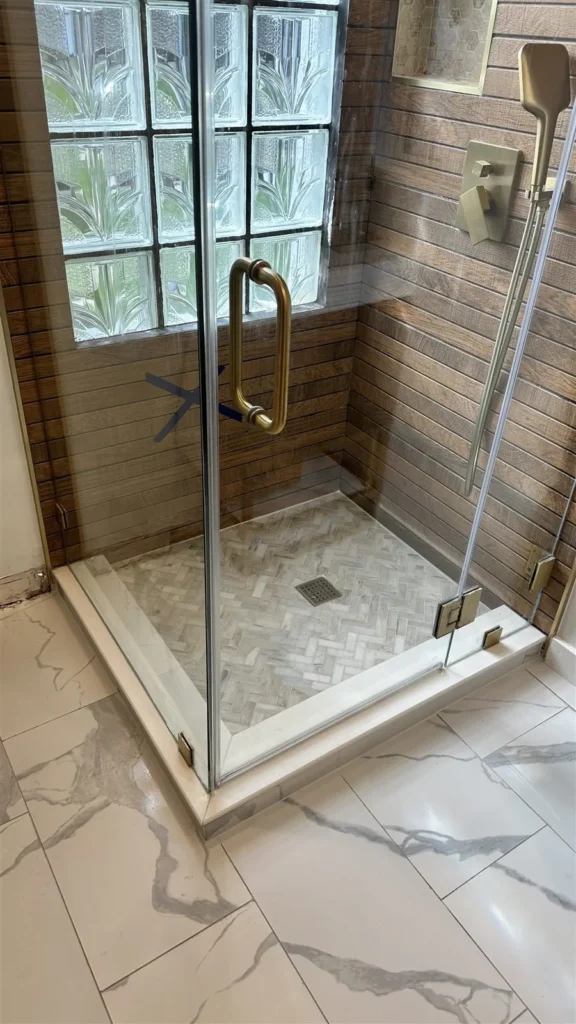 Frameless glass shower with pebble floor installed in Los Angeles