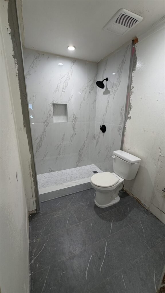Marble-look shower and floor tile in a Los Angeles bathroom