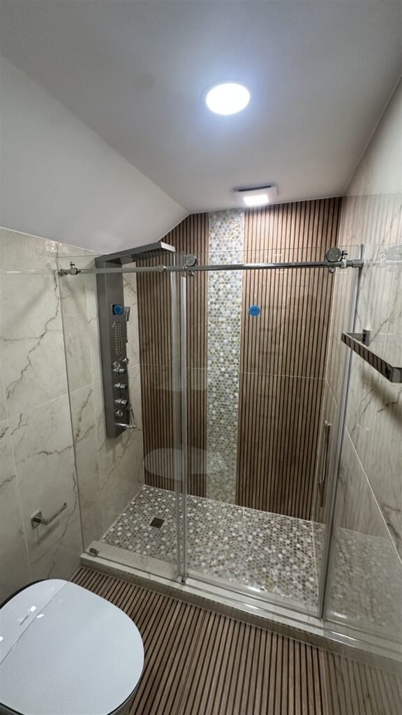Walk-in shower with wood-look and marble tile in Los Angeles
