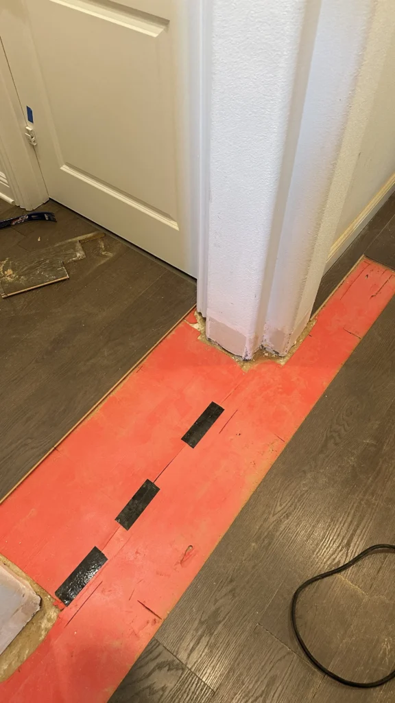 Transition strip set at a doorway before installation in a Los Angeles home