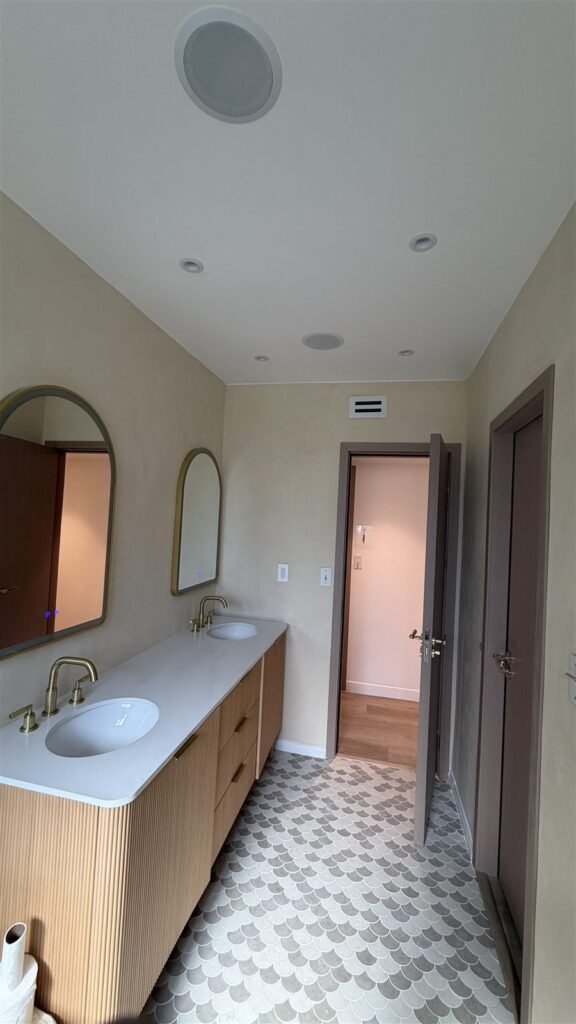 Finished bathroom with vanity and arched mirror in Los Angeles