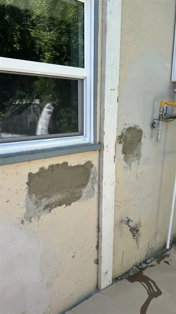Stucco patched around a window before paint in Los Angeles