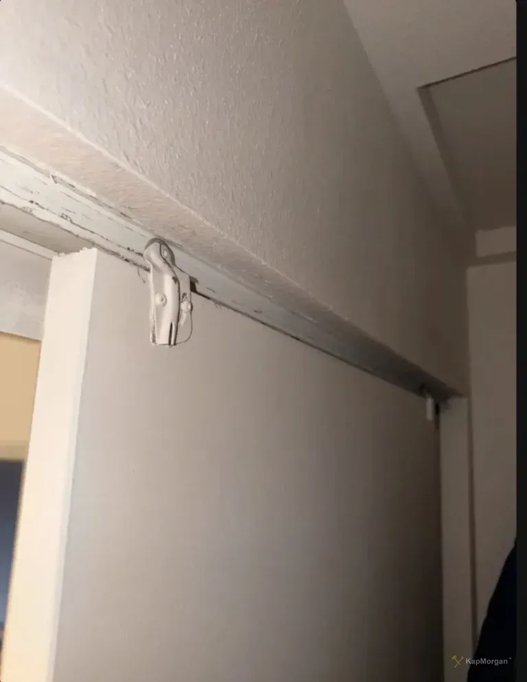 Before: worn track and roller at top of closet door frame, Van Nuys